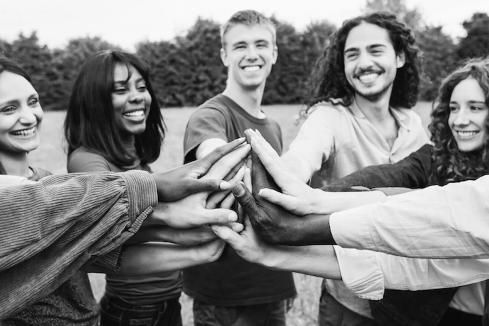 A team stacking hands together outdoors