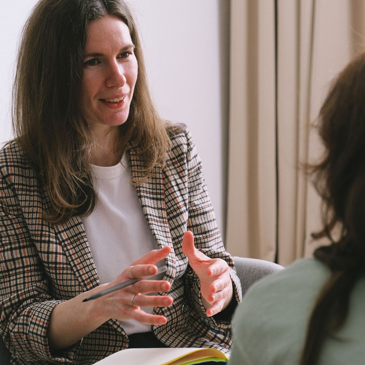 Therapist about page — warm counseling conversation between therapist and client